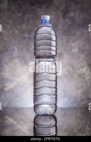 Plastic cold bottle of water with water drops. Stock Photo