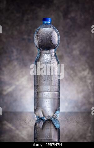 Plastic cold bottle of water with water drops. Stock Photo