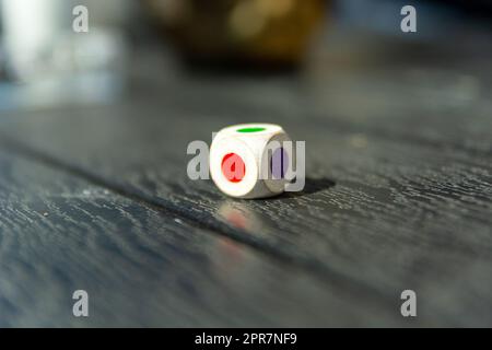 Dice with colored dots on the table Stock Photo