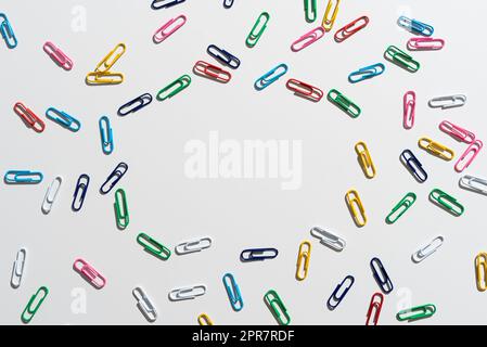 Colorful Paperclips Placed Around Important Information. Colored Clips Arranged In Circle With Crutial Announcement Inside. Staples With Recent Ideas Written In. Stock Photo