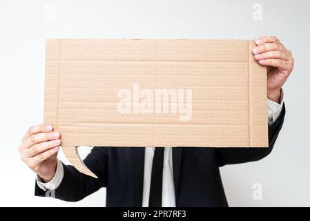 Businessman Holding Speech Bubble With Important Messages. Man In Suit Presenting Crutial Informations On Dialogue Balloon. Gentleman Showing Recent Updates On Paper. Stock Photo