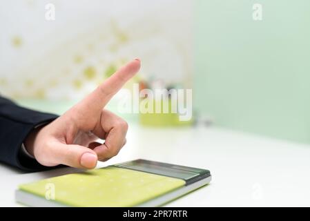 Businesswoman Pointing On Important Message With Calculator And Notebook On Desk. Woman Presenting News On Table With Notepad. Executive Displaying Recent Informations. Stock Photo