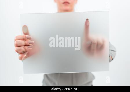 Female Worker Holding Blank Placard And Making Important Announcement. Businesswoman With Banner In Hands Promoting And Marketing The Company Brand To Achieve Business Goals. Stock Photo