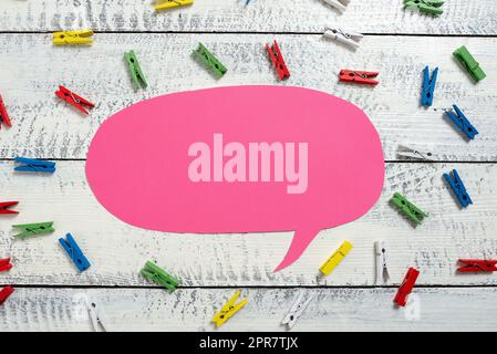 Colorful Pegs Placed Around Speech Bubble With Important Information. Wooden Clips Arranged All Over Dialogue Ballon With Crutial Idea. Pins With Critical Data Inside. Stock Photo