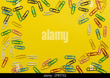 Colorful Paperclips Placed Around Important Information. Colored Clips Arranged In Circle With Crutial Announcement Inside. Staples With Recent Ideas Written In. Stock Photo