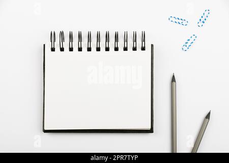 Notebook With Important Message On Desk With Pens And Paperclips. Notepad With Crutial Information On Table With Pencils And Colored Clips. Presented Late News. Stock Photo