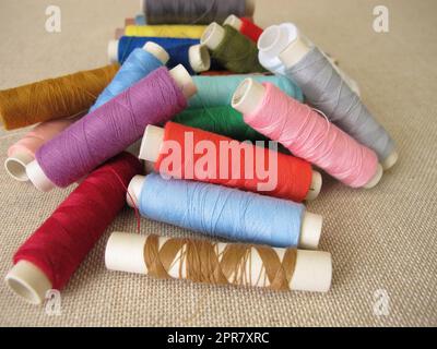 Sewing thread in different colors on farbric Stock Photo