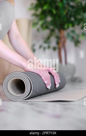 Close-up of a woman's hands preparing a mat for yoga or meditation. Stock Photo