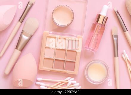 Natural beige eye shadow and decorative cosmetics on light pink, top view Stock Photo