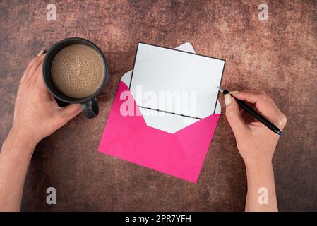 Hands Of Woman With Pen, Blank Paper, Envelope And Coffee Cup Over Wooden Background. Businesswoman Having Drink And Writing Crucial Message On Business Letter. Stock Photo