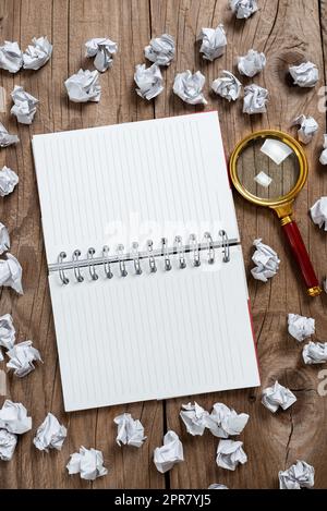 Notepad Opened On Both Pages With Important Data Written In With Paper Wraps And Magnifier Around. Notebook On Ground With Crutial News Inside And Crumpled Notes All Over. Stock Photo