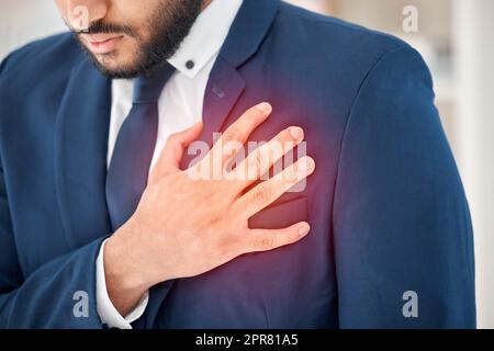 What could this pain be. Shot of an unrecognizable businessperson suffering from chest pain at work. Stock Photo