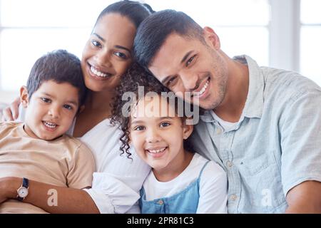 A family doesnt have to be perfect, just united in love. Portrait of a happy family bonding together at home. Stock Photo