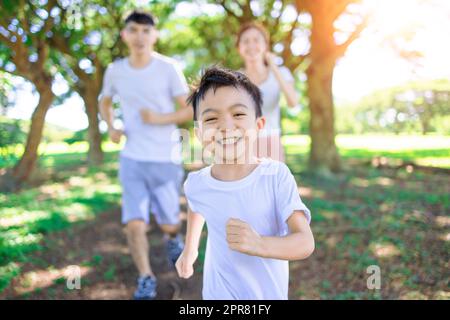 Happy boy  Jogging with parents in the city park Stock Photo