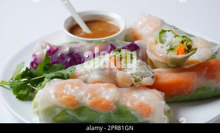 Vietnamese Spring Rolls Goi Cuon or Nem Cuon,  filled with prawns, herbs, rice vermicelli and vegetables. Served with hoisin and peanut sauce dip. Stock Photo