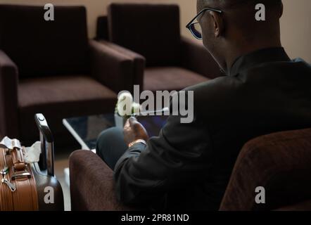 Businessman working on tablet PC at airport lounge. Stock Photo