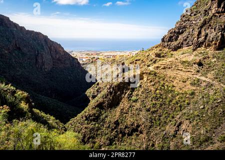 Enjoy a breathtaking panoramic view of the Atlantic Ocean stretching out towards the horizon with Adeje and La Caleta  from the Barranco del Infierno. Stock Photo