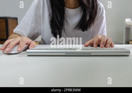 Female person holding mouse and keyboard computer. Technology internet information browsing online social media and network concept. Stock Photo