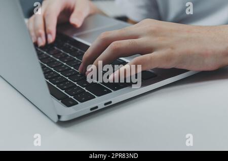 close up hand woman typing keyboard computer laptop on desk.Business technology online and communication on desk. Stock Photo