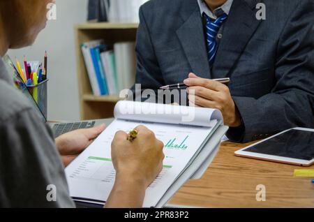Business people meeting at the office by analyzing data from financial graphs and investment charts to plan a marketing team. Stock Photo