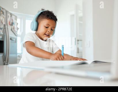 Stay in the lines. a little boy doing his homework at home. Stock Photo