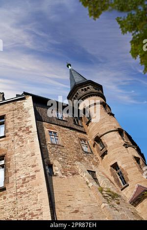 Exterior of a gothic victorian building in the style of England Gothic Revival on a cloudy blue sky with copy space. Low architecture detail of an historical church tower structure or University Stock Photo