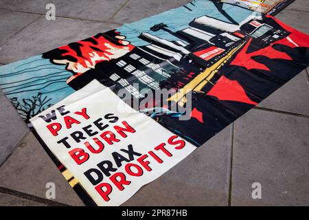 London, UK. 26th April, 2023. A banner brought by environmental activists to a protest outside the annual general meeting of the UK's largest bioenergy supplier Drax is pictured. UK energy regulator Ofgem is investigating Drax’s compliance with sustainability rules amid increasing scrutiny of the company's activities, including of its source wood and its descriptions of the process used to generate electricity as 'carbon neutral'. Government biomass subsidies to Drax are currently expected to expire in 2027. Drax has today announced its highest ever annual profits, £731m as compared to £398m t Stock Photo