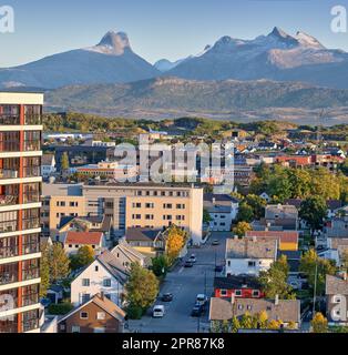 A small city surrounded by nature with a mountain in the background. A landscape of buildings in a scenic vacation location. Cityscape of an urban town as a holiday destination Stock Photo