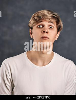 handsome guy grimacing on a dark gray background Stock Photo