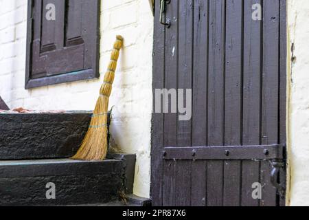 Broom on the threshold of a country house. Broom near the entrance to a house in the countryside. Stock Photo