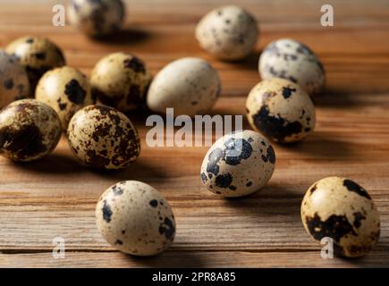Many quail eggs placed against a wooden background. Stock Photo