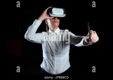 Businesswoman Wearing Virtual Reality Simulator And Holding Pen. Woman Wearing Vr Headset While Attending Professional Training Through Modern Technology. Stock Photo