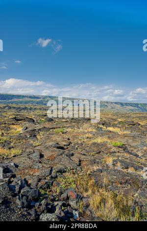 Landscape view of Big Island of Hawaii with copy space. Scenic view of Mauna Kea dormant volcano with copyspace. Vast expanse of cooled lava flow in nature and blue sky near a summit of volcanic land Stock Photo