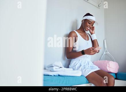 Live in peace with yourself. a young woman listening to music in a locker room. Stock Photo