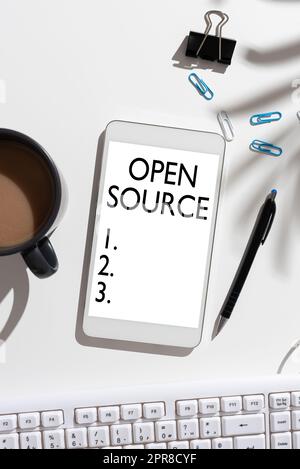 Text sign showing Open Source. Business overview denoting software which original source code freely available Mobile Phone Screen With Important Message On Desk With Coffee And Keyboard Stock Photo