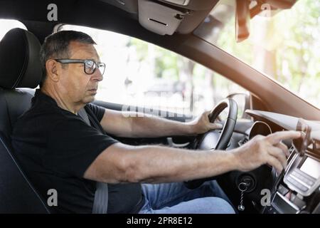 Senior behind the steering wheel using gps navigation Stock Photo