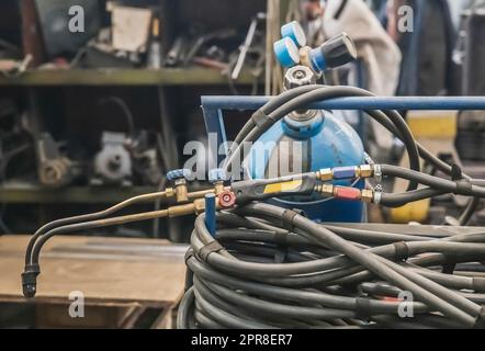 Gas cylinder, hose and blowtorch at the factory Stock Photo
