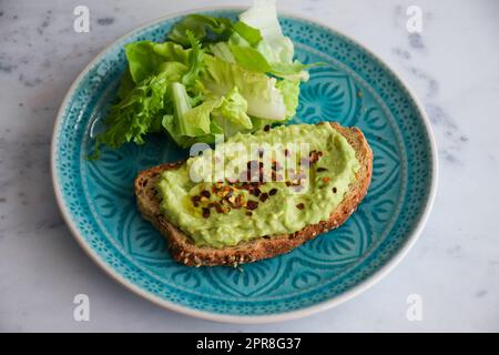 Avocado on toast, guacamole on bread, yummy breakfast meal, Keto Diet idea, Delicious Healthy nutritious meal, Brunch idea, white background, Blue Stock Photo