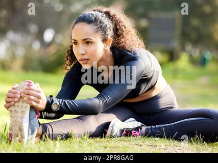 Goals set in motion. Shot of a young woman enjoying her morning yoga outside. Stock Photo