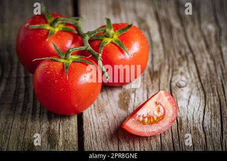 Bunch of fresh, red tomatoes on a wooden rustic board. Healthy and fresh ripe Stock Photo