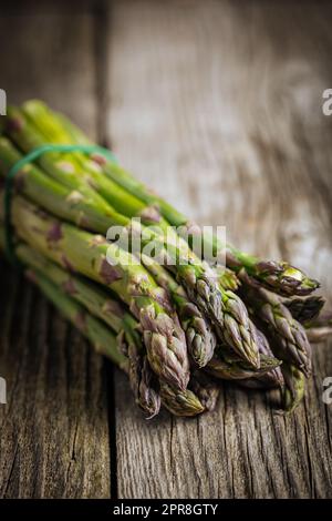 Bunch of green asparagus on rustic wooden board. Fresh and seasonal ingredient. Stock Photo