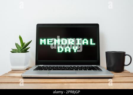 Conceptual caption Memorial Day. Word for To honor and remembering those who died in military service Lap Top With Important Information On Table With Plant And Cup Of Coffee. Stock Photo