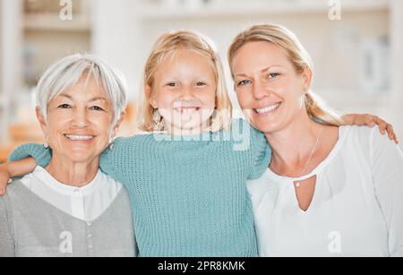 Spending time with the girls. Cropped portrait of an adorable little girl at home with her mother and grandmother. Stock Photo