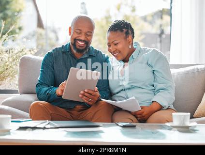 The days are best spent with you. a mature couple looking through their bills while using a digital tablet. Stock Photo