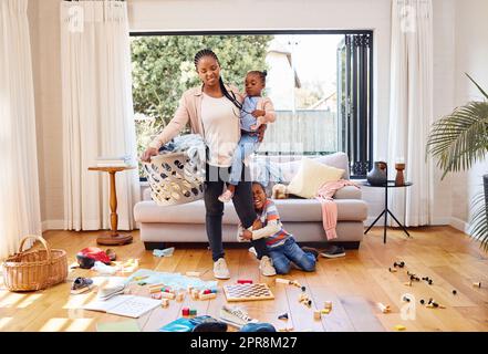 Dont let the pressures of life get to you. a little boy throwing a tantrum while holding his mothers leg at home. Stock Photo