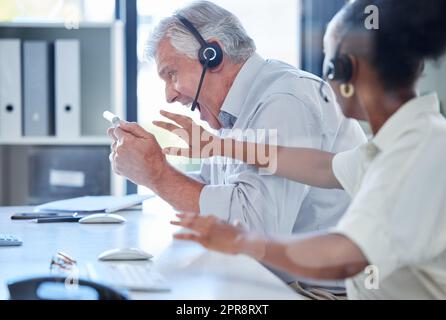 When rage takes over. a mature call centre agent getting angry and screaming at a computer keyboard while working in an office. Stock Photo