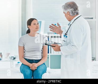 The new treatment is experimental. a doctor discussing a patients results with her using a digital tablet. Stock Photo