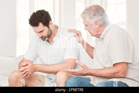 Ill help you through this. a father consoling his son at home. Stock Photo