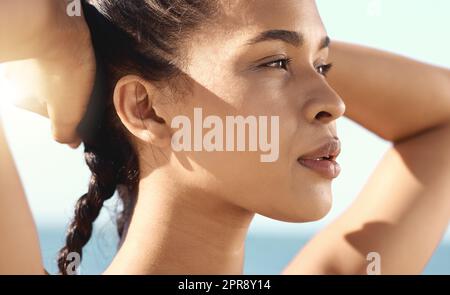 Close up of a beautiful female athletes face while taking a break while stretching and putting her hands behind her head Stock Photo
