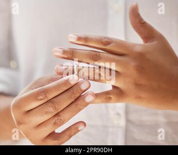 Close up of woman taking off wedding ring. Hands removing or putting on ring. Wife making hard decision to leave husband in unhappy marriage Stock Photo